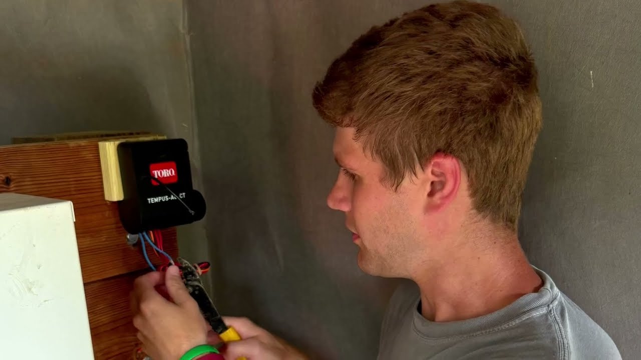 A grower wiring a Toro Tempus controller during installation